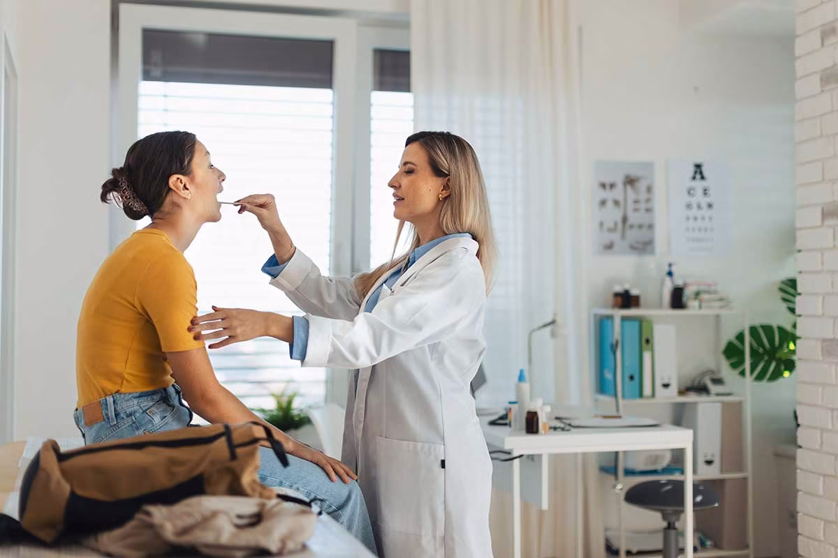 Allgemeinmedizin – Ihre Hausarztpraxis in Berlin-Mitte 7 doctor examining young patient sore throat hausaerztin alexanderplatz berlin mitte